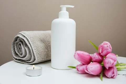 Toalla, crema y tulipanes en una cabina de tratamiento
