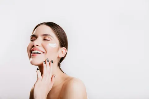 Mujer aplicándose crema en el rostro