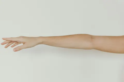 Brazo extendido sobre fondo claro