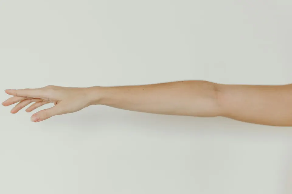 Brazo extendido sobre fondo claro