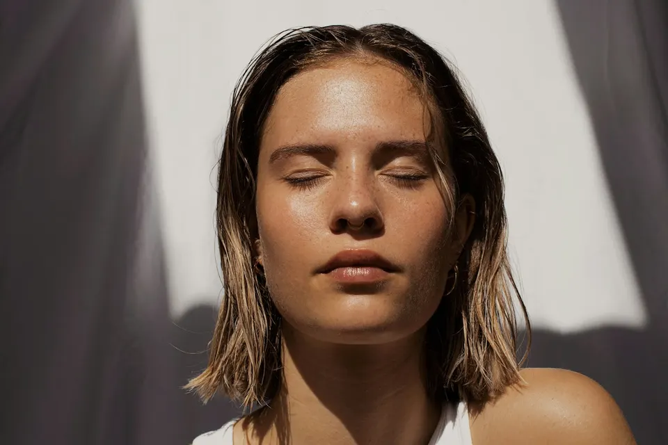 Retrato de mujer con los ojos cerrados bajo luz natural