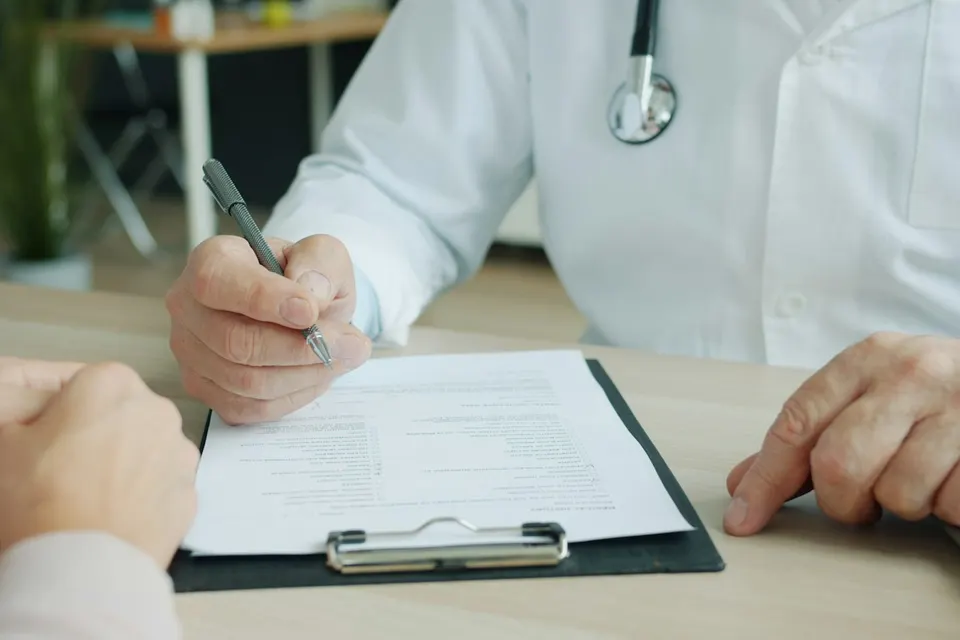 Doctor taking notes during a consultation