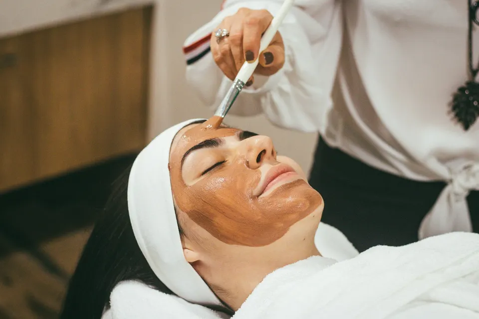 Mujer recibiendo un tratamiento facial en cabina